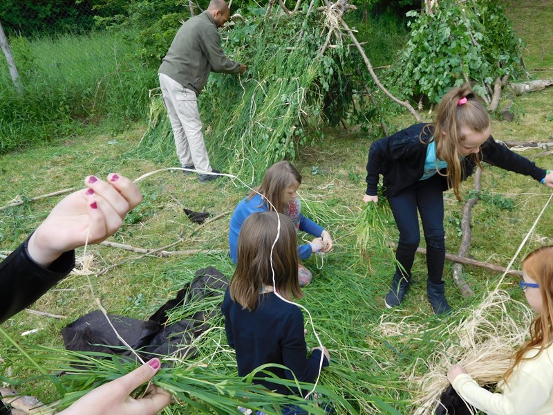 Kinder bauen Laubhütten.