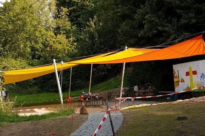 Ein orange Sonnensegel spenden Schatten