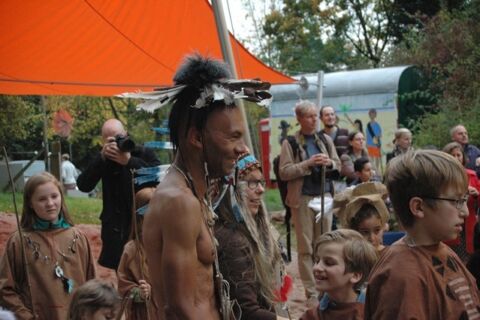 Ein Indianer steht lachend in der Menschenmenge