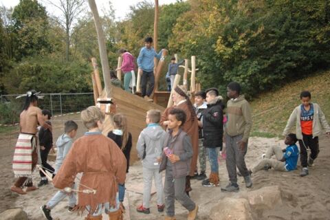 Das Piratenschiuff aus Holz im Sandkasten, mit vielen spielenden Kindern