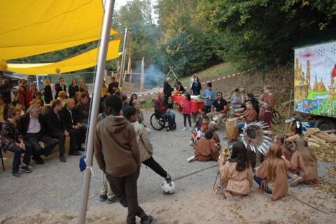 indianisch gekleidete Trommelgruppe im Halbkreis vor Publikum