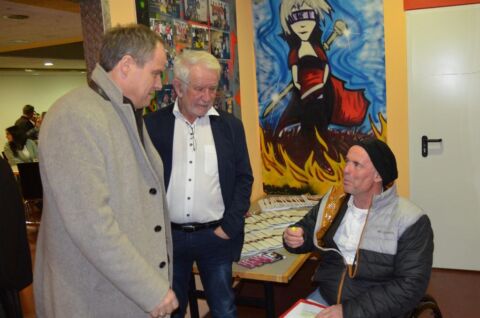 Drei Personen im Bild eine Person sitzt im Rollstuhl